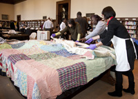 Reviewers examine a quilt during the Treasures program. Credit: Michael Barnes, Smithsonian.